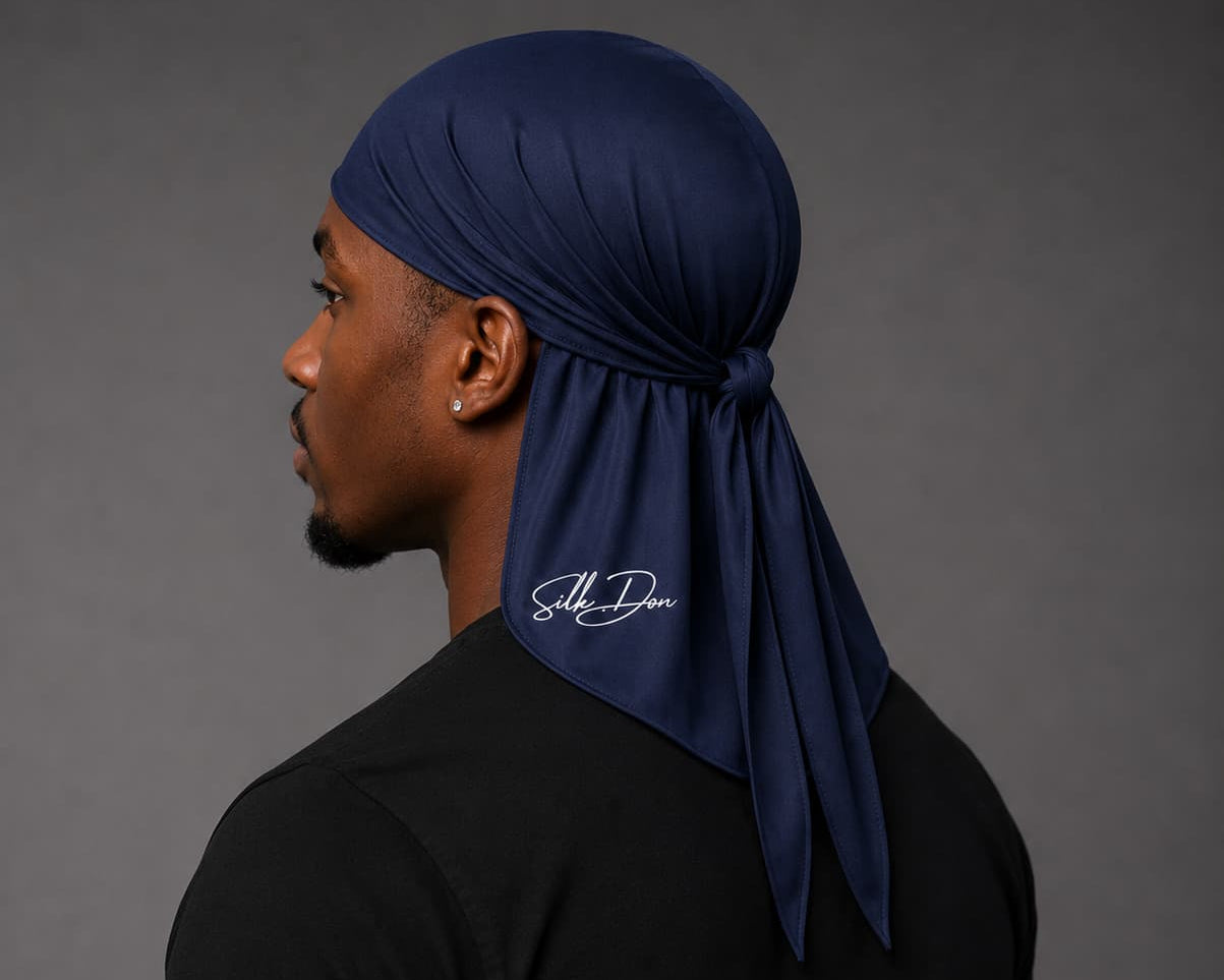 Man wearing a navy blue durag with a SilkDon logo on a gray background