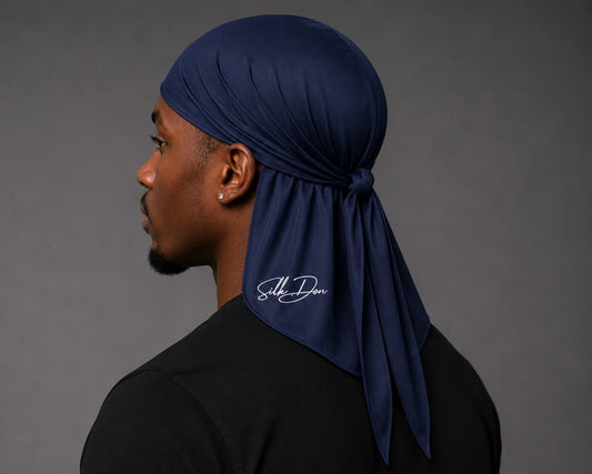 Man wearing a navy blue durag with a SilkDon logo on a gray background
