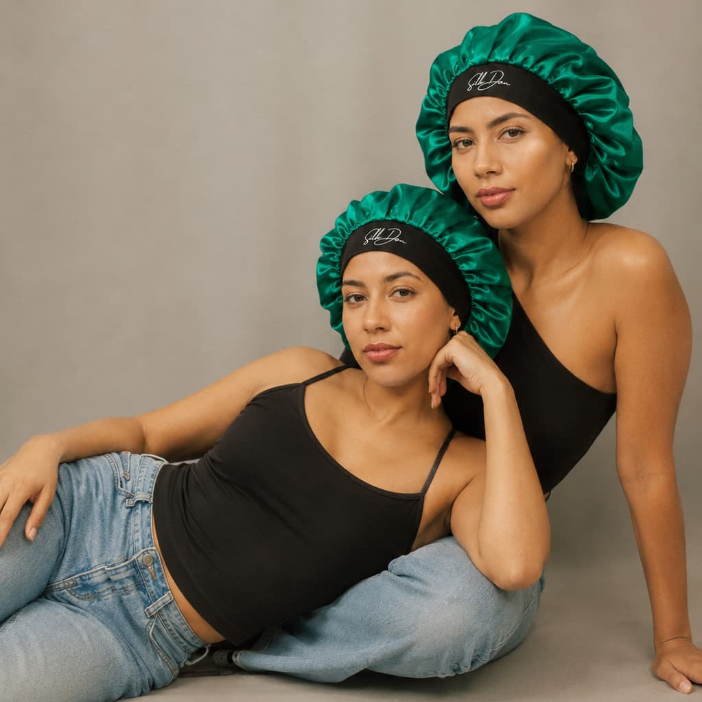 Two women wearing green SilkDon bonnets on a neutral background