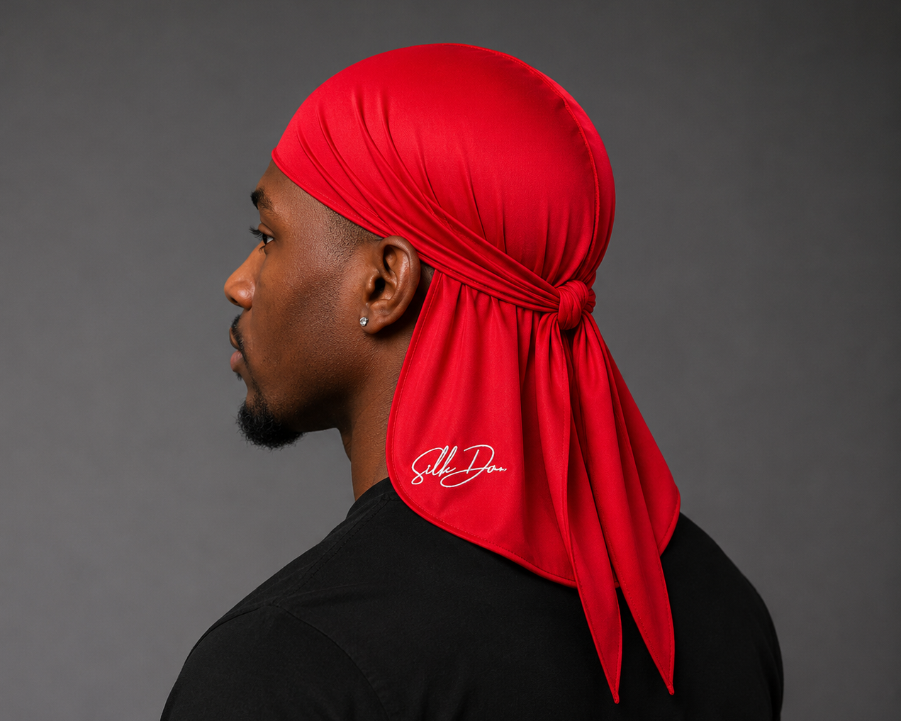Man wearing a red durag with SilkDon logo on a gray background